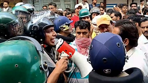 Security personnel interact with people following stone-pelting incidents during protests against the proposed removal of a portion of the 'Shahi Masjid