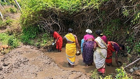 Tribal women of Mangappara settlement collect water from muddy spring for drinking purposes