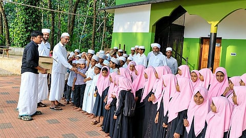 എലാംപ്രയിൽ എൽ.പി. സ്കൂൾ സ്ഥാപിക്കാൻ സർക്കാർ അനുമതി നൽകിയതിനെത്തുടർന്ന് തെന്നത്ത് മുഹമ്മദ് ഫൈസി കുട്ടികൾക്ക് മധുരം വിതരണം ചെയ്യുന്നു.