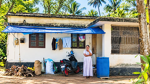 Santhosh’s wife lilly in front of their house