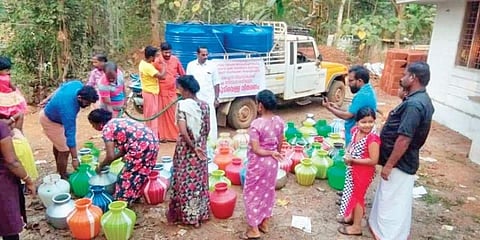 കുടുംബങ്ങള്‍ക്ക് വെള്ളം നല്‍കുന്ന സേവാഭാരതി പ്രവര്‍ത്തകര്‍/ചിത്രം: എക്‌സ്പ്രസ്‌