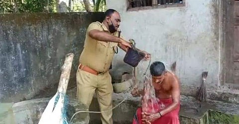 യുവാവിനെ വീട്ടിലെത്തി കുളിപ്പിക്കുന്ന പൊലീസിന്റെ ചിത്രം/ ഫെയ്‌സ്ബുക്ക്‌