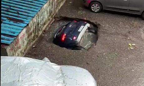 കനത്തമഴയില്‍ രൂപപ്പെട്ട ഗര്‍ത്തത്തില്‍ കാര്‍ താഴ്ന്നുപോകുന്നു, വീഡിയോ ദൃശ്യം