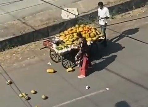 ഉന്തുവണ്ടിയിലെ പപ്പായ റോഡിലേക്ക് വലിച്ചെറിയുന്ന സ്ത്രീ