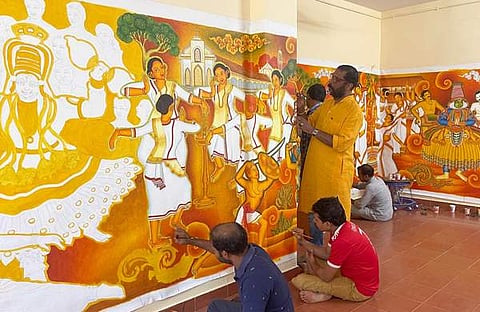 കൊച്ചി അന്താരാഷ്ട്ര വിമാനത്താവളത്തിലെ ബിസിനസ് ടെര്‍മിനലിന്റെ പ്രവേശന കവാടത്തില്‍ ചുമര്‍ചിത്രത്തിന്റെ നിര്‍മ്മാണ പ്രവര്‍ത്തനങ്ങളില്‍ ഏര്‍പ്പെട്ടിരിക്കുന്ന ഡോ. ടി. എസ്. സാജുവും ടീം അംഗങ്ങളും