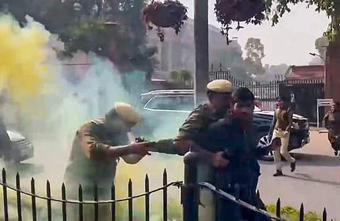 മഞ്ഞകലര്‍ന്ന പുക പുറന്തള്ളുന്ന ക്യാനുമായി പാര്‍ലമെന്റ് മന്ദിരത്തിന് പുറത്ത് പ്രതിഷേധിച്ച ഒരാളെ പൊലീസ് പിടികൂടുന്നു/ പിടിഐ, ഫയല്‍