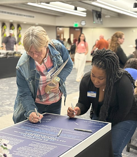 Community Members Signing the 100 Families Initiative Declaration of Participation at the Ingham County Launch in April 