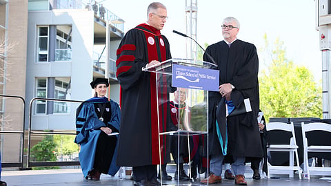 Ted Dickey (left), member of the University of Arkansas Board of Trustees, presents Restore Hope Executive Director Paul Chapman with an honorary Master of Public Service degree.