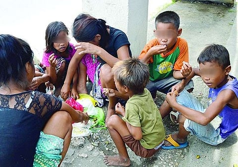 Children share a meal near a flyover in Lapu-Lapu City in this image taken during the 2013 election campaign. 