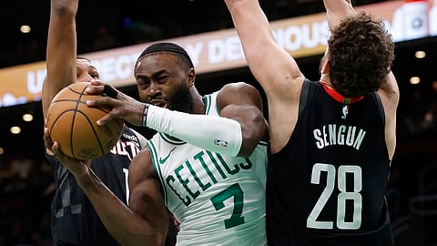 BOSTON Celtics’ Jaylen Brown (middle) drives between Houston Rockets’ Amen Thompson (left) and Alperen Sengun (right) during the second half of an NBA basketball game Saturday, Jan. 13, 2024, in Boston. 
