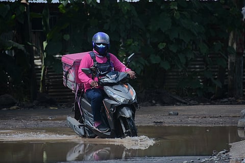 PADAYON. This food delivery rider pushes through with his delivery itinerary despite the huge puddle of water in an area in Matina Pangi, Davao City. 