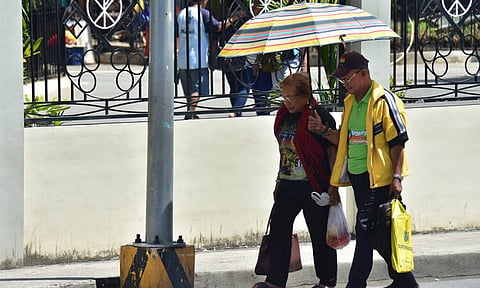 NOON TIME HEAT. An elderly couple brave the noontime heat along San Pedro Street.
