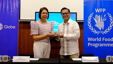 Yoly Crisanto, Globe Chief Sustainability and Corporate Communications Officer, and Dipayan Bhattacharyya, WFP Philippines Country Director ad interim, seal their partnership to address involuntary hunger in the Philippines.