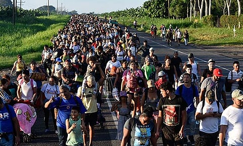 Migrants walk along the highway through Suchiate, Chiapas state in southern Mexico, Sunday, July 21, 2024, during their journey north toward the U.S. border. 
