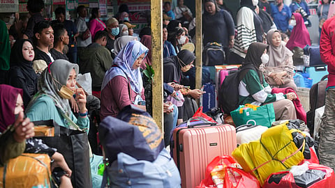 People wait for a bus to take them back home towns ahead of the Eid al-Fitr holiday at Pondok Pinang Bus Terminal in Jakarta, Indonesia, Thursday, March 27, 2025. (AP Photo)
