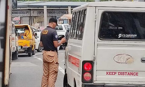 CRACKDOWN.  An enforcer from the Land Transportation Office issues a ticket to a vehicle along Ulas, Davao City. In March, the LTO apprehended 18,882 motor vehicles nationwide as part of its ongoing campaign against unregistered or 'colorum' vehicles.