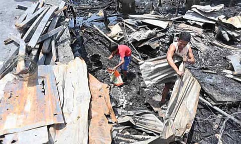 PICKING UP THE PIECES. After a massive fire razed some 400 homes in Barangay 21-C, Piapi Boulevard, Davao City, Thursday afternoon, October 2, 2025,  residents return to the blackened ground where their houses once stood. With nothing left but ashes, families dig through the rubble—scraping for iron sheets, wood, and anything they can use to rebuild. They search for fragments of their former lives, carrying what little they can salvage. What once was home is now dust, but the will to start over burns stronger than the fire that destroyed everything.