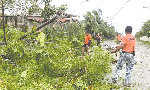 AFTERMATH. Members of the Philippine Coast Guard clear toppled trees and debris following typhoon Tino, which caused widespread power outages across Cebu. The Cebu Electricity Rights Advocates has urged power utilities to strengthen grid resilience and fast-track restoration efforts in affected areas. / 