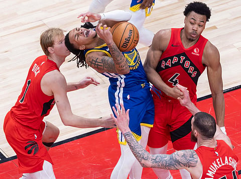 SWARMED BY RAPTORS. Golden State’s Will Richard (center) clutches the ball as he is swarmed by Toronto’s Gradey Dick (1), Scottie Barnes (4), and Sandro Mamukelashvili during the Raptors’ 141-127 overtime victory. Toronto’s aggressive defense forced 21 Warriors turnovers. / 