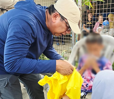 ZAMBOANGA. Basilan Governor Mujiv Hataman on Monday, January 26, attends to a 10-year-old boy, one of the 223 survivors of a ferry sinking, brought to the port of Isabela City. Each survivor received P5,000 in cash assistance from the provincial government.