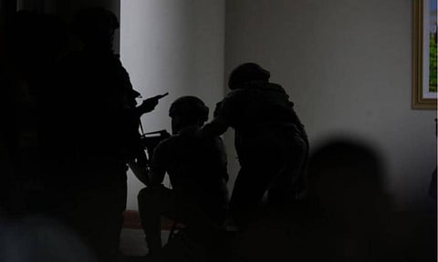 Armed Philippine Marines troops stationed at the Senate take defensive position after a volley of gunshots was fired, prompting a security lockdown on Wednesday evening, May 13, 2026