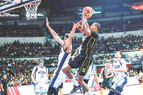 CHRIS McCullough (No.5) of the TNT Tropang 5G attacks the defense of Patrick Gardner (left) of the Meralco Bolts in the Philippine Basketball Association Season 50 Commissioner’s Cup semifinals. / PBA IMAGES 
