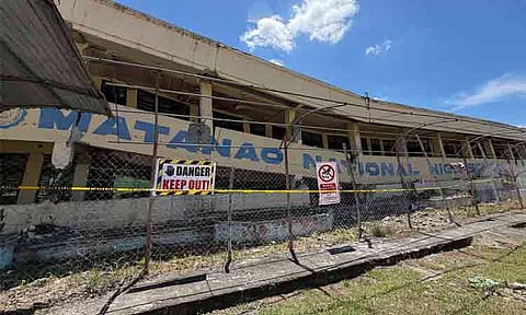 The structural damage to a building at Matanao National High School in Davao del Sur following a strong earthquake. The structure shown was previously condemned and scheduled for demolition following previous earthquakes in 2019. It was not being used as an active facility for classes at the time of the recent June 2026 earthquake. The area has been cordoned off with fencing and warning signs to prevent access and ensure safety.
