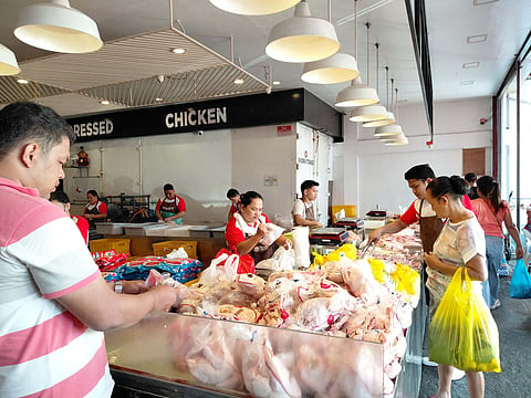 Customers buy dressed chicken at a stall in Bankerohan Public Market in Davao City.