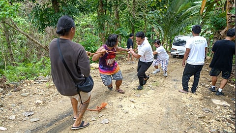 COMMUNITY POWER. Local residents and organizers navigate a steep, unpaved road in Cebu, Philippines, pulling supplies to reach mountainous project sites as part of the CarbonPH initiative. Managed by the Aboitiz Foundation, the flagship 40-year nature-based climate solutions program relies on grassroots Bayanihan efforts to restore 71,000 hectares of protected forest landscapes and revitalize vital regional watersheds.