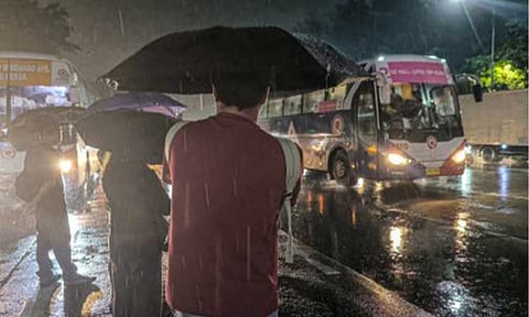 RAINY COMMUTE. Commuters wait for their rides along Elliptical Road in Quezon City on Thursday (Aug. 6, 2026). The southwest monsoon (habagat) will continue to bring moderate to heavy rains over Metro Manila until Saturday (Aug. 8). (PNA photo by Joan Bondoc)