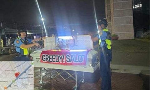 SINISTER MOVE. Quezon City Police District officers recover two abandoned caskets with attached banners at the 11th World Scout Jamboree Memorial Rotonda in Barangay South Triangle and at Mabuhay Rotonda early Friday (Aug. 7, 2026). The QCPD has formed a Special Investigation Team to identify those responsible and determine their motive. (Photo courtesy of QCPD)