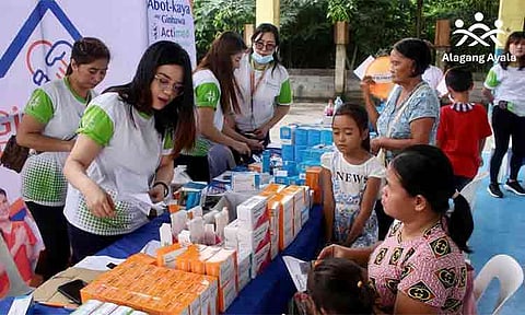 Volunteers and healthcare workers distribute free essential medicines to local residents during a community medical mission organized by Alagang Ayala, AC Health, and Generika Drugstore in the Philippines. The corporate social responsibility initiative aims to improve healthcare access and provide affordable medicine to underserved grassroots communities.