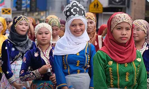 Participants wearing vibrant traditional attire and elaborate headpieces smile during the annual Kadayawan Festival parade on Sunday morning, August 16, 2026. The festive street event brought together members of Davao City’s 11 ethnolinguistic communities and Indak-Indak sa Kadayawan contingents to showcase the rich cultural pride and heritage of the region.