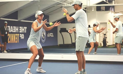 PRE-GAME DRILL. World No. 5 Iga Swiatek, wearing headphones, concentrates intensely while doing a reaction drill with a male coach just before her quarterfinal match against No. 2-ranked Elena Rybakina in the Cincinnati Open. Swiatek advanced to the semis as Rybakina was forced to retire in the first set due to ankle injury. / CINCINNATI OPEN