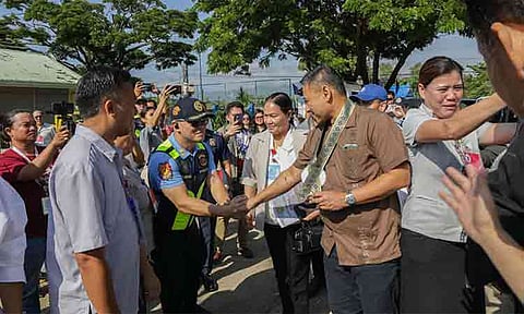 Department of Education (DepEd) Secretary Sonny Angara (center-right) shakes hands with local police and community officials during an official school inspection visit. Angara toured several public schools across the region to evaluate campus safety protocols, engage with local educators, and assess infrastructure needs to ensure secure learning environments for students.