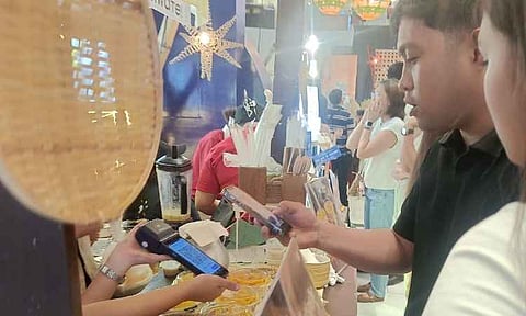 CASHLESS SHOPPING. Shoppers use GCash to pay for purchases at the Designers’ Holiday Bazaar at Ayala Malls Abreeza in Davao City, giving customers a faster and more convenient way to shop while supporting cashless transactions for local MSMEs.