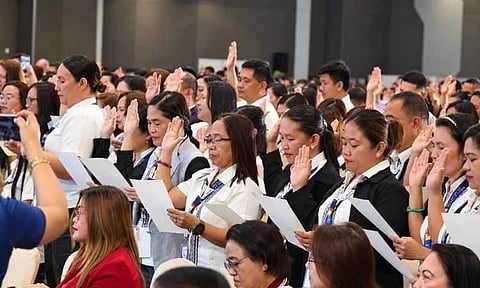Newly promoted public school teachers and school heads raise their right hands as they take their oath of office during a mass ceremony led by Department of Education (DepEd) Secretary Sonny Angara at the SMX Convention Center in SM Lanang, Davao City, Oct. 1, 2026. A total of 1,814 educators from across the Davao Region participated in the event, held during the 12th Regional Assembly of Education Leaders, marking a milestone under the government's Expanded Career Progression (ECP) system.