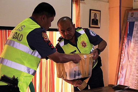 BENGUET. La Trinidad Municipal Police seal the deposited licensed firearms of barangay candidates to deter crime and ensure a peaceful and orderly elections. (Lauren Alimondo)