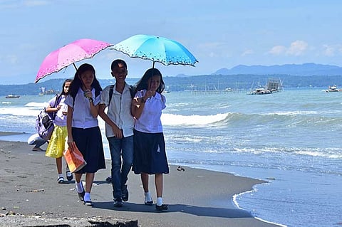 DAVAO. Students going home from school walk along the beach for a cooler way towards home rather than the main road in Barangay 76-C, Bucana in Davao City. (Macky Lim)