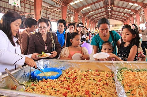 BAGUIO. Residents and stakeholders of the La Trinidad Vegetable Trading Post celebrate its 34th founding anniversary by serving 50 kilos of vegetable salad on July 13. (Photo by Lauren Alimondo)