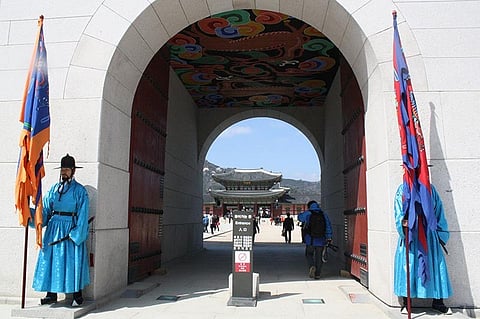 Guards garbed in bright uniforms stand by the Gwanghwamun gate. Claire Marie Algarme 