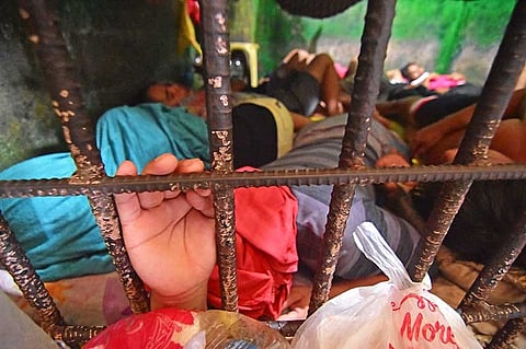 DAVAO. A person deprived of liberty holds the cell bars while sleeping with other detainees inside the Sasa Police Station in Davao City on Sunday, January 6. (Macky Lim)