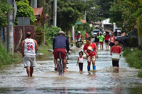 DAVAO. Residents of Jade Valley Subdivision in Davao City wade through the subdivision's flooded main street.