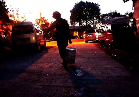 A BUCKET. Siana Abacajan, 64, of Barangay Maghaway Talisay City, goes home with a bucket of water, her reward for lining up to get water from barrels filled by a fire truck. Abacajan has to do this several times a day as water supply in her area is dwindling. (SunStar photo / Alex Badayos)