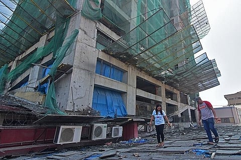 DAVAO. Maintenance personnel of a Boy Scouts of the Philippines building on CM Recto Street, Davao City inspect their roof after debris from a high-rise building next to the establishment damaged their roof and power transformer, which caused power outages and leaks inside the commercial building. (Photo by Macky Lim)