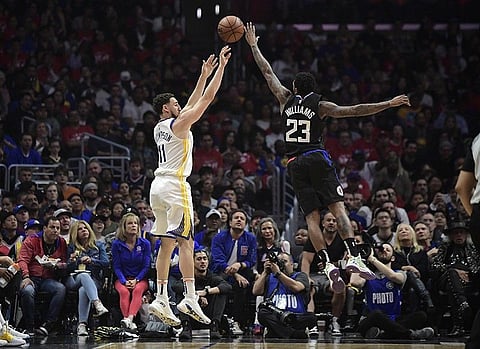 Golden State Warriors guard Klay Thompson, left, shoots as Los Angeles Clippers guard Lou Williams defends during the first half in Game 4 of a first-round NBA basketball playoff series Sunday, April 21, 2019, in Los Angeles.  (AP Photo)