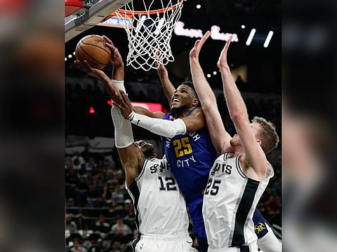 Denver Nuggets guard Malik Beasley (25) drives to the basket between San Antonio Spurs center LaMarcus Aldridge (12) and center Jakob Poeltl (25) during the first half of Game 6 of an NBA basketball playoff series, Thursday, April 25, 2019, in San Antonio. (AP Photo)