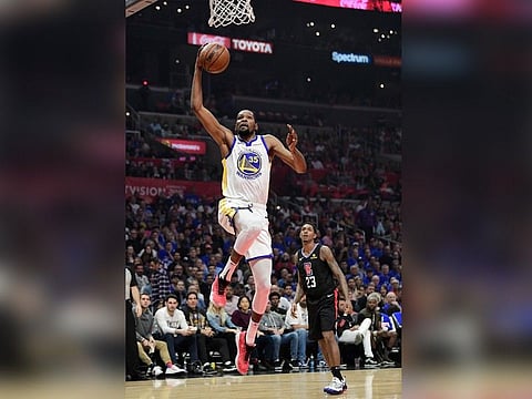 Golden State Warriors forward Kevin Durant, left, shoots as Los Angeles Clippers guard Lou Williams defends during the first half in Game 6 of a first-round NBA basketball playoff series Friday, April 26, 2019, in Los Angeles. (AP Photo)