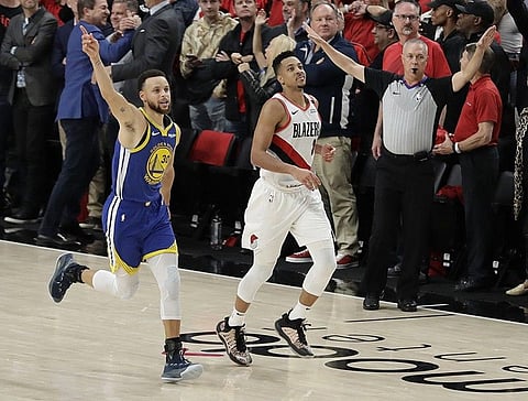 Golden State Warriors guard Stephen Curry, left, celebrates as he runs next to Portland Trail Blazers guard CJ McCollum, center, at the end of Game 4 of the NBA basketball playoffs Western Conference finals, Monday, May 20, 2019, in Portland, Ore. The Warriors won 119-117 in overtime. (AP)