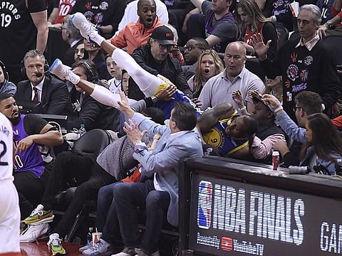 Golden State Warriors guard Andre Iguodala falls into the stands during the first half of Game 1 against the Toronto Raptors in basketball's NBA Finals, Thursday, May 30, 2019, in Toronto. (AP)